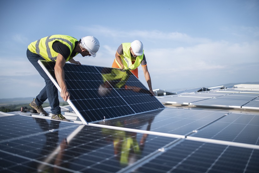 Two engineers installing solar panels on roof. Tiling Services